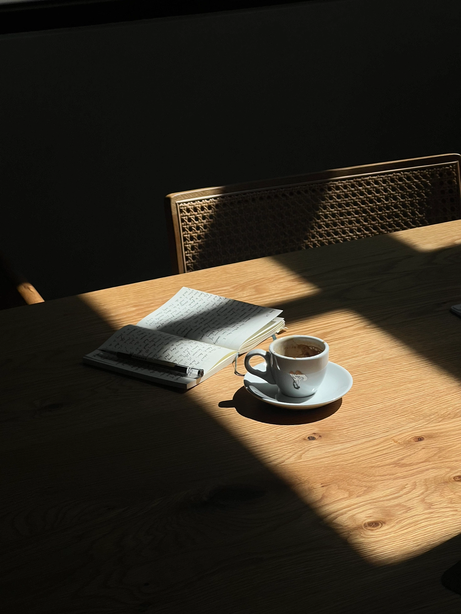 Cuaderno y café sobre una mesa de madera